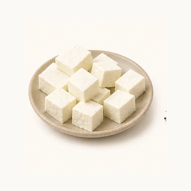 Fresh white paneer cubes on a ceramic plate