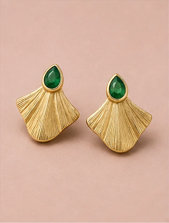 Fan-shaped brushed gold earrings with emerald stones